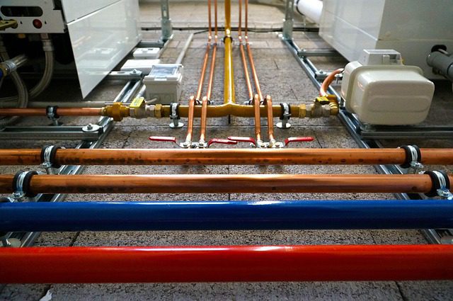 Industrial pipes with valves and fittings in a mechanical room.